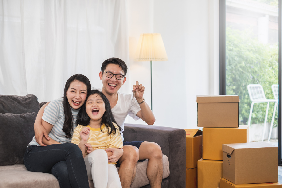 Asian family moving to new home/house holding keys house